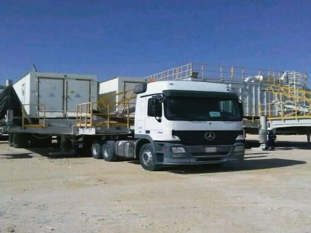 Ajyal truck moving a camp unit on a lowbed across the desert