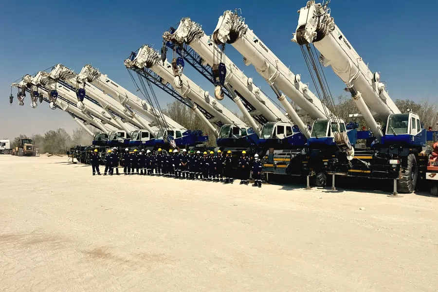 Ajyal's rough-terrain crane line with booms raised and crews beneath, Al Khobar yard