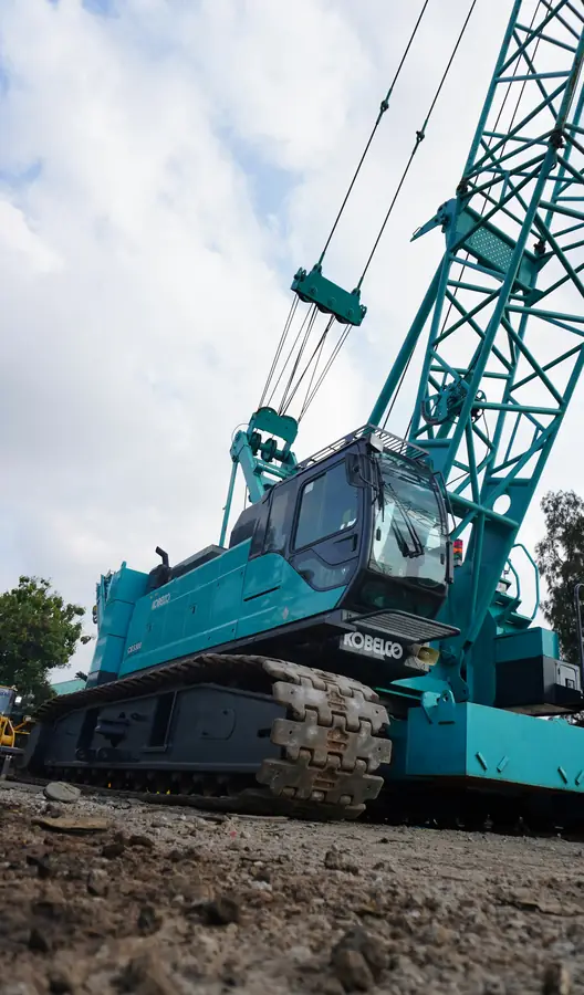 Crawler crane from ground level, treads and lattice boom rising overhead