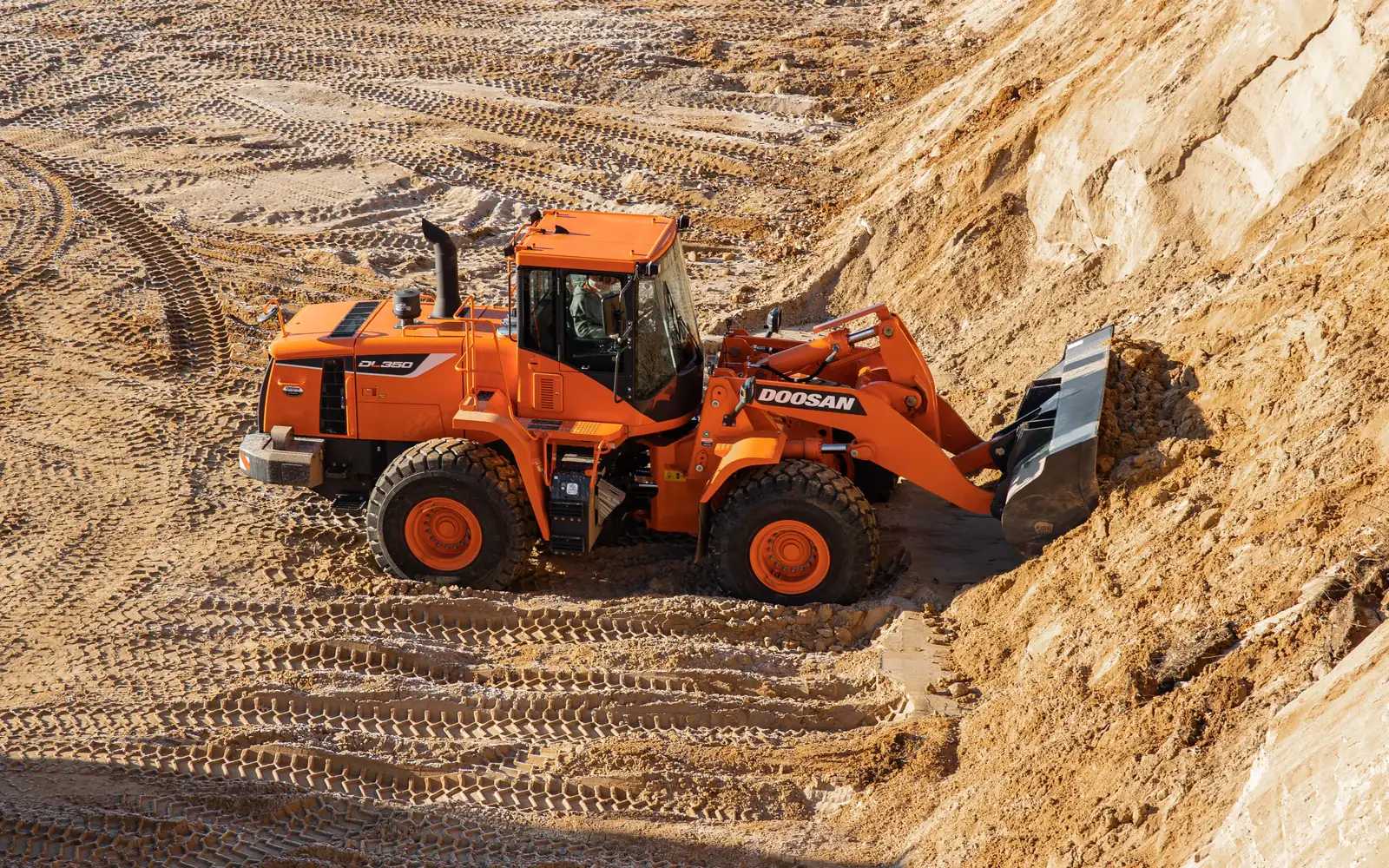 Doosan wheel loader working a golden sand stockpile