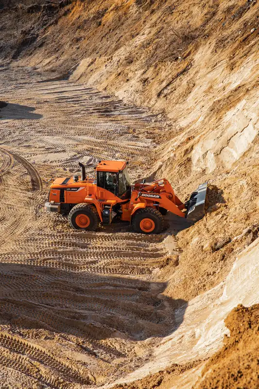 Doosan wheel loader working a golden sand stockpile
