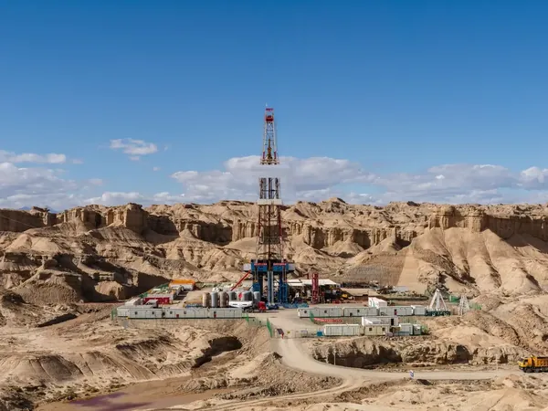 Land drilling rig and its camp among desert rock formations