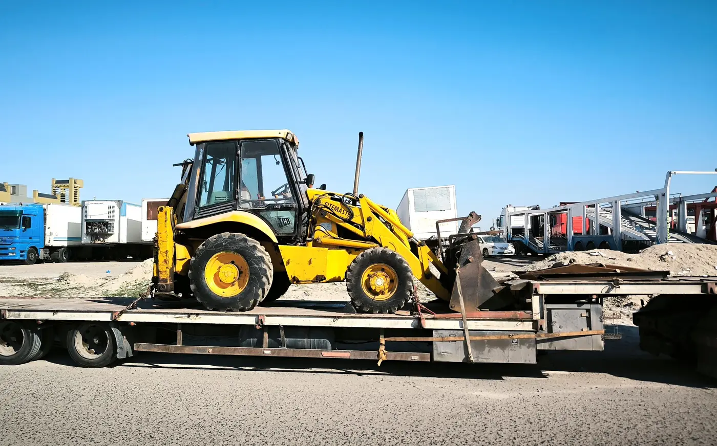 Tracked plant chained down on a lowbed trailer