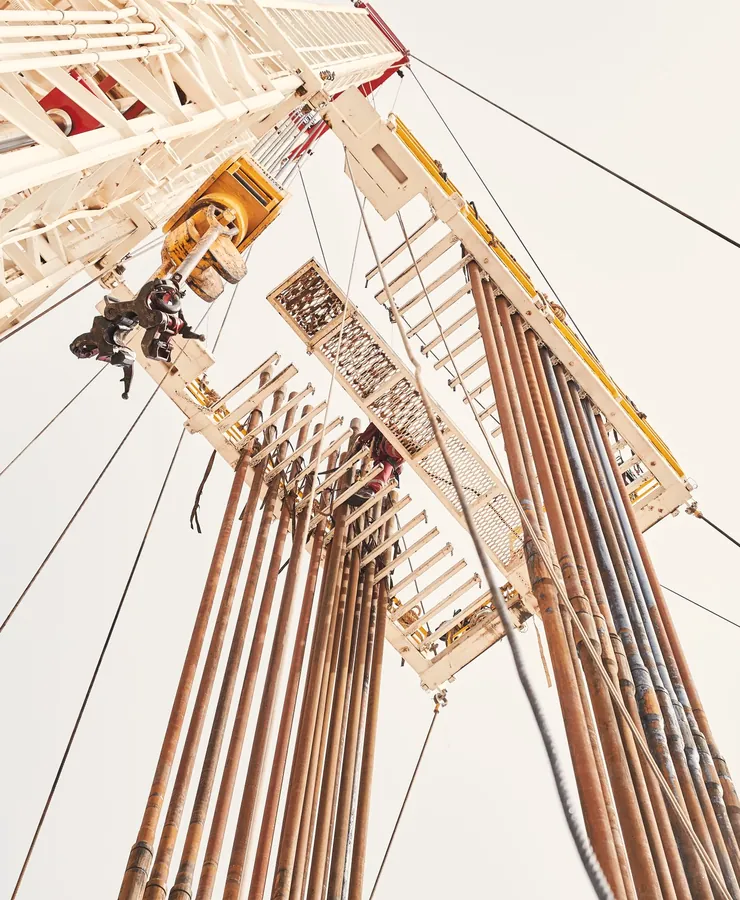 Rig mast crown and lines seen from the pad