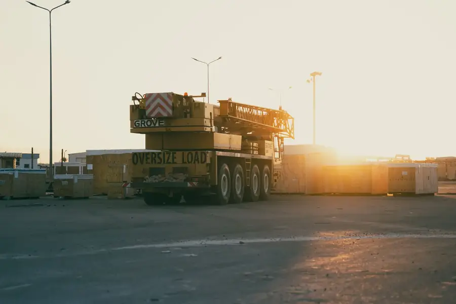 All-terrain mobile crane parked in a yard at golden hour