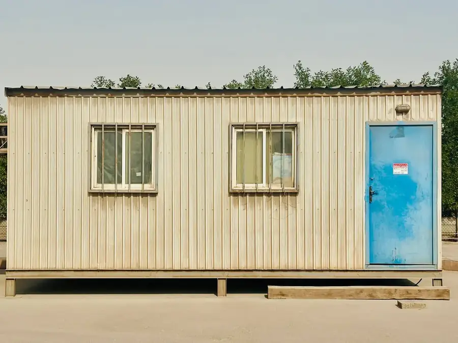 Site portacabin on a dusty Saudi yard in warm light