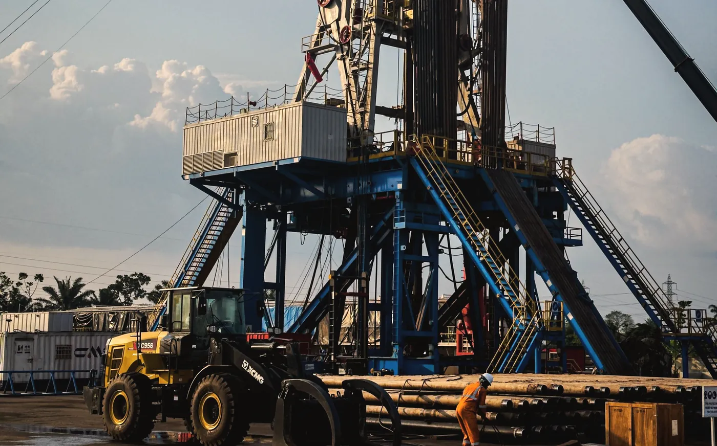 Loader handling pipe beneath a rig substructure during load-out