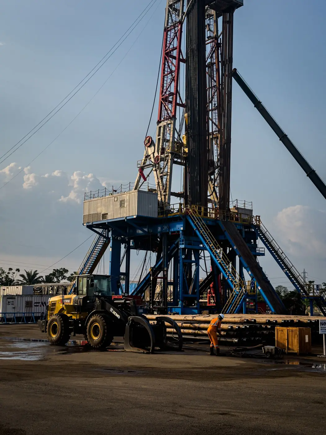 Rig site with loader and crew at dusk